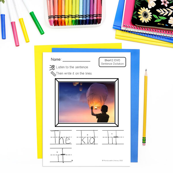 Printed short I CVC sentence dictation page of boy holding a sky lantern and sentence The kid lit it.