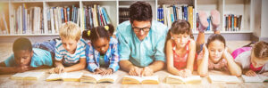 Decodable sentences featured image of a teacher and students lying on the floor reading books.