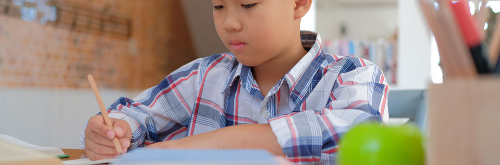 Featured image of a boy applying phonics to writing.